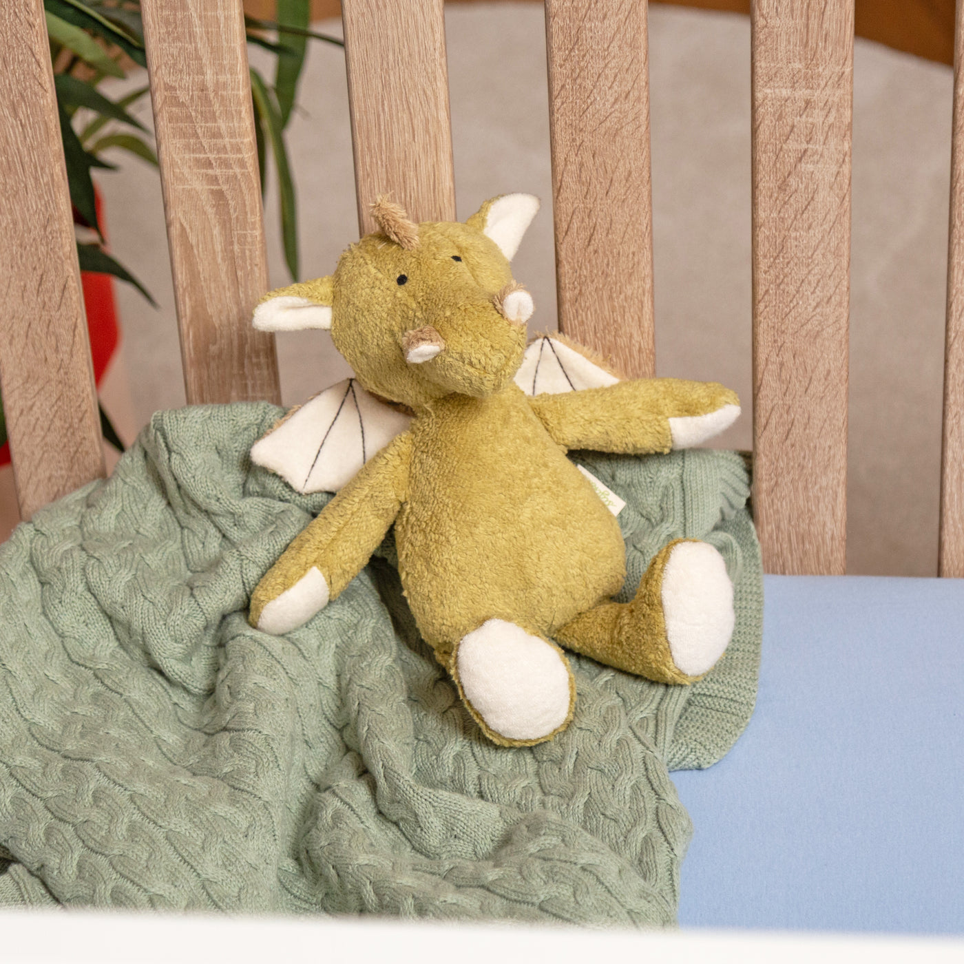 Bio-Kuscheltier Drache sitzend im Kinderbett