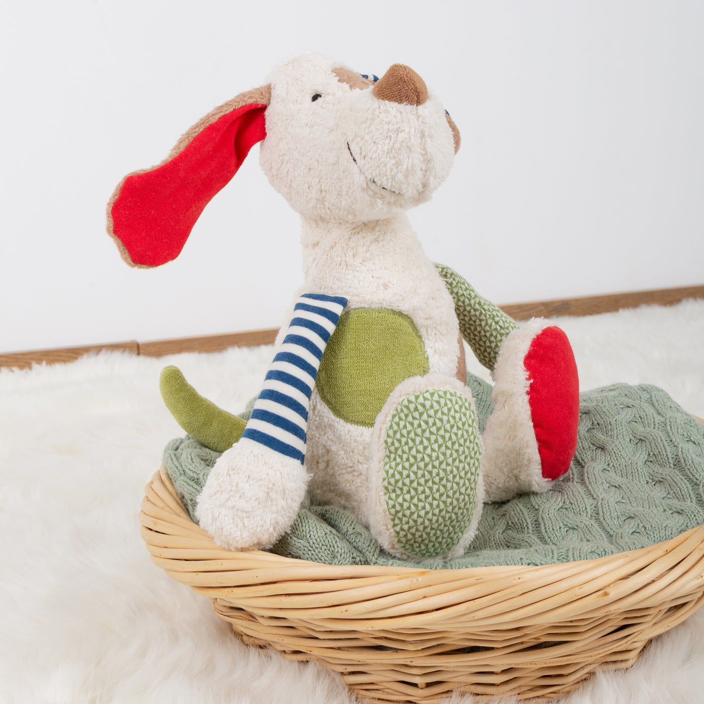 Sigikid Hund Kuscheltier auf einem Korb sitzend