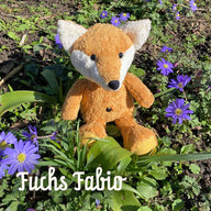 Bio Kuscheltier Fuchs Fabio auf Wiese mit Blümchen sitzend